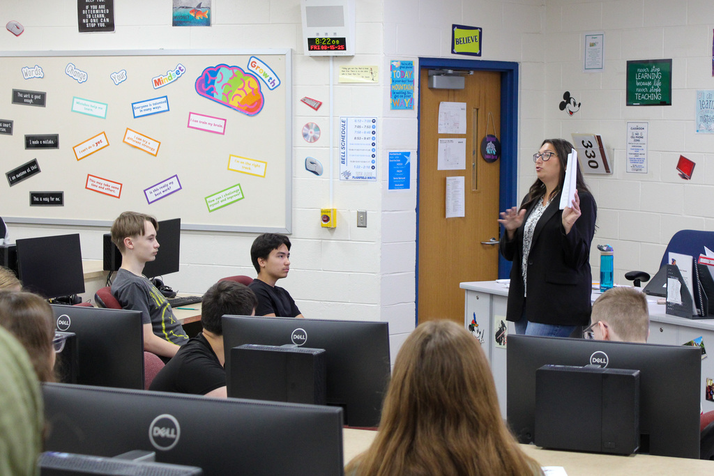 teacher hold up paper in front of class
