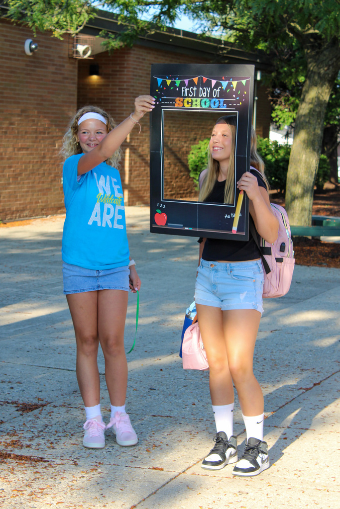 students get photos taken with head in fun frame