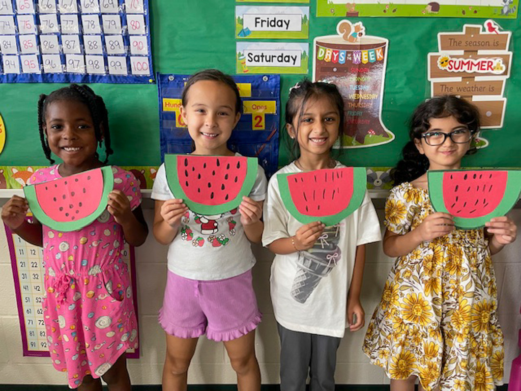 four students hold homemade watermelons