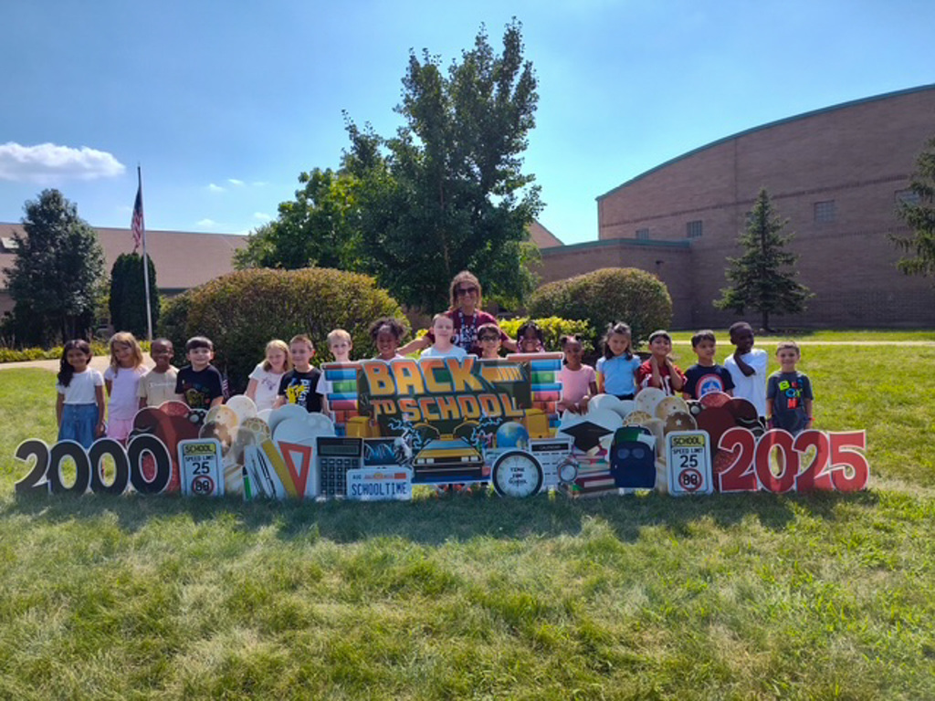 group of students stand in front of sign. Back to School, 2000-2025
