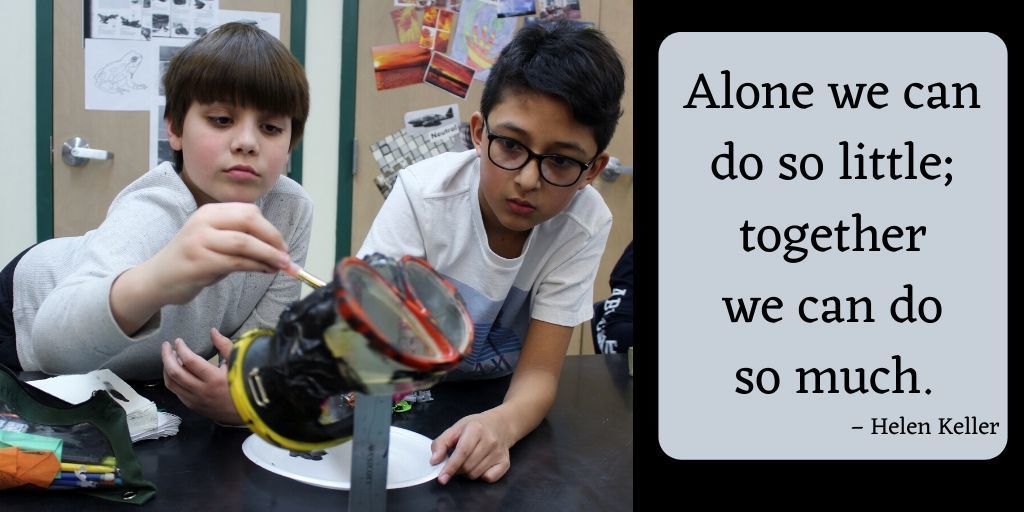 two boys painting a scuba mask. Alone we can do so little; together we can do so much