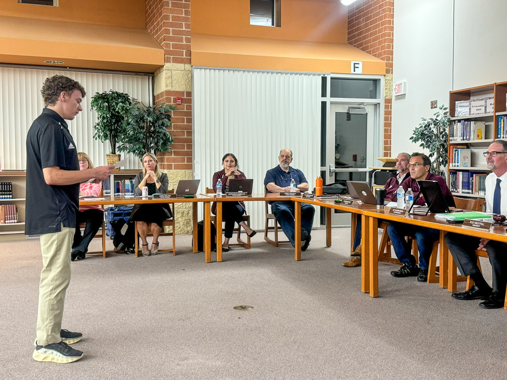 student stands and speaks in front of the School Board