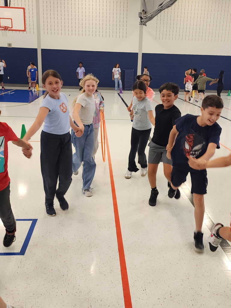 Student students in a gym, walking and holding hands