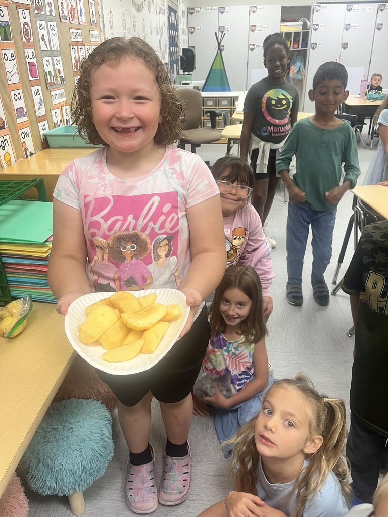 A student is holding a plate of sliced apples.