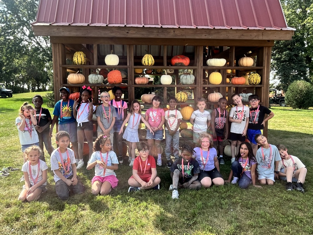 Students in a group posing for a picture in front of a pumpkin display