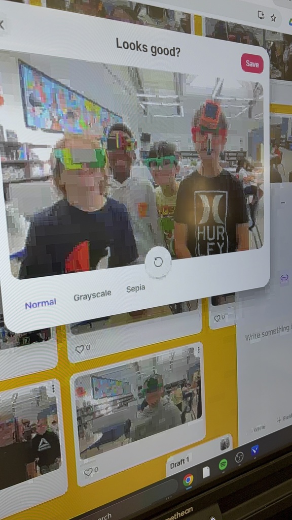Four students in a library taking a picture on the laptop. 