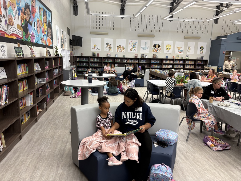 Parents and children reading in a library. 