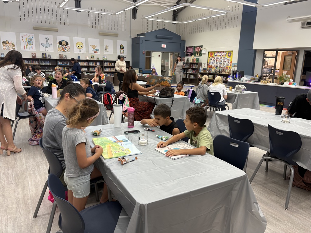 Parents and children reading in a library. 