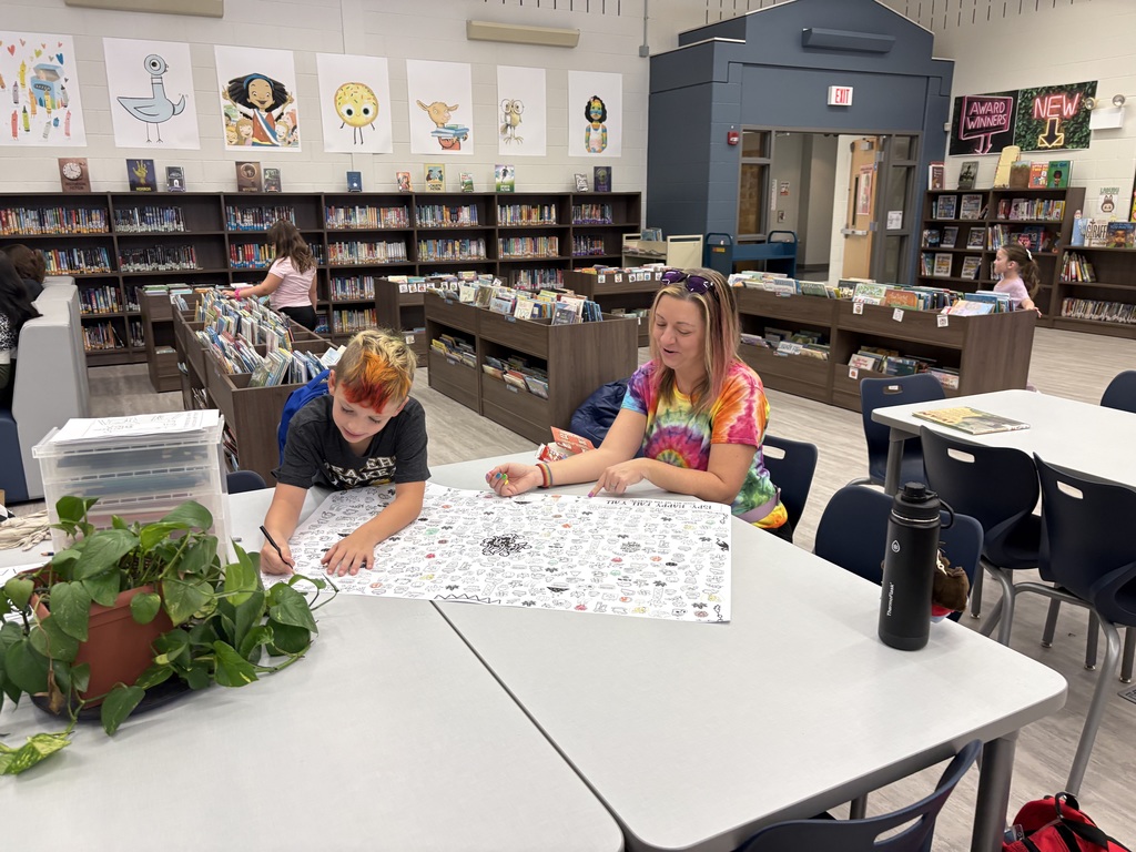 Parents and children reading in a library. 