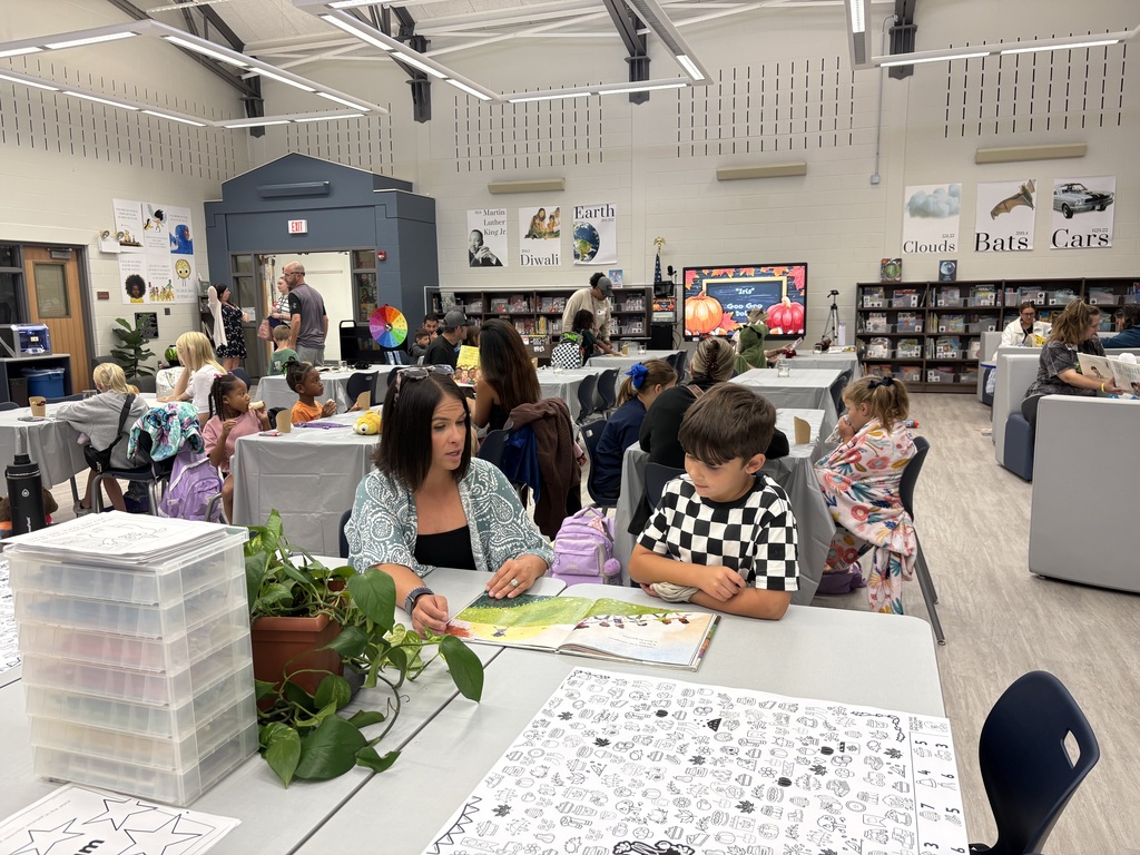Parents and children reading in a library. 