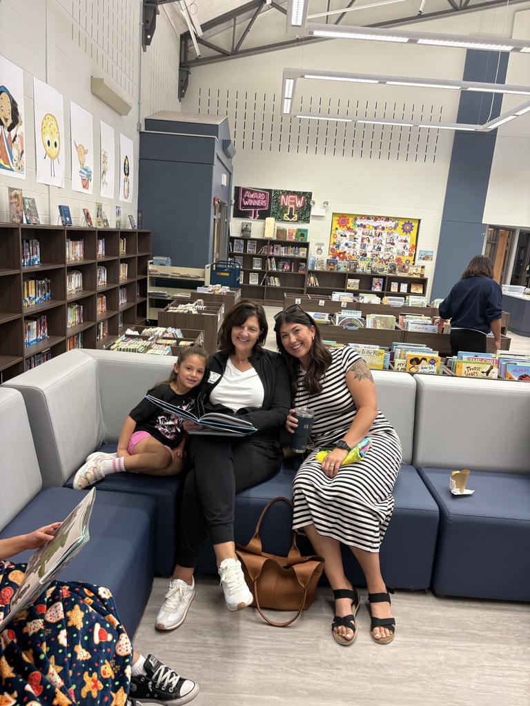 Parents and children reading in a library. 