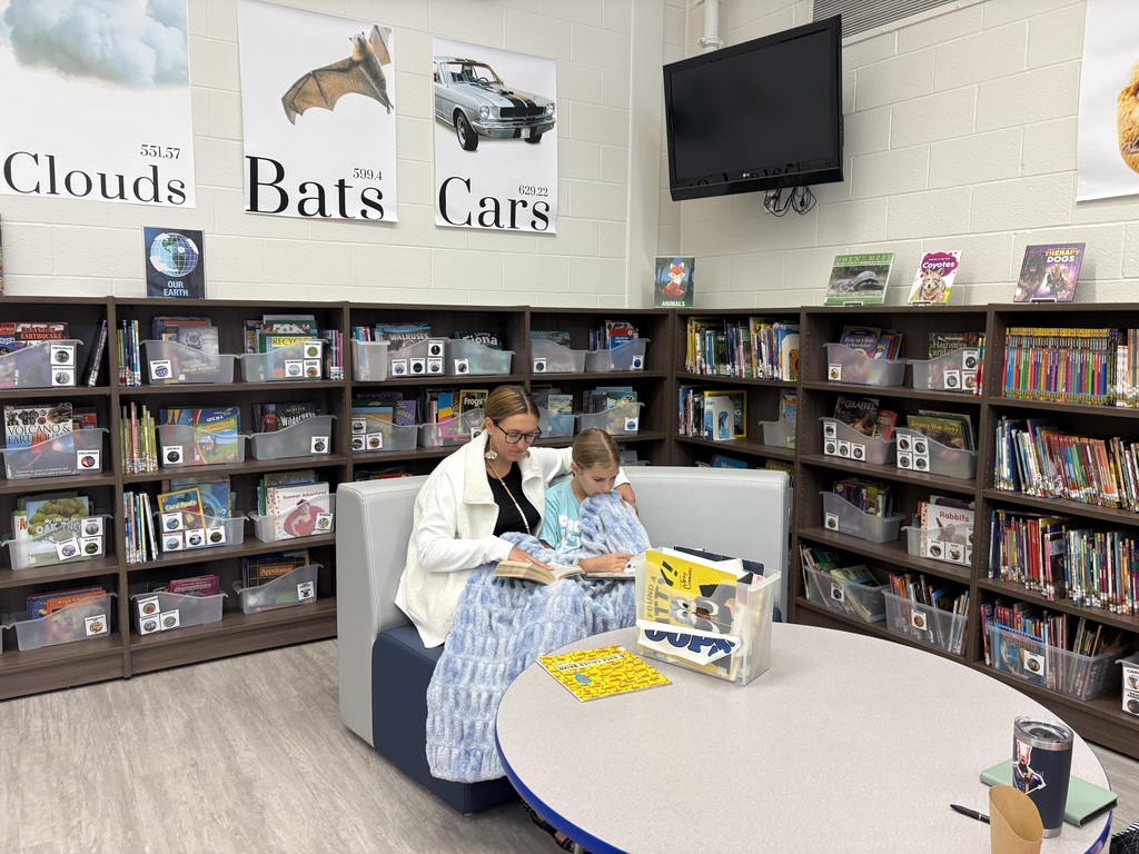 Parents and children reading in a library. 
