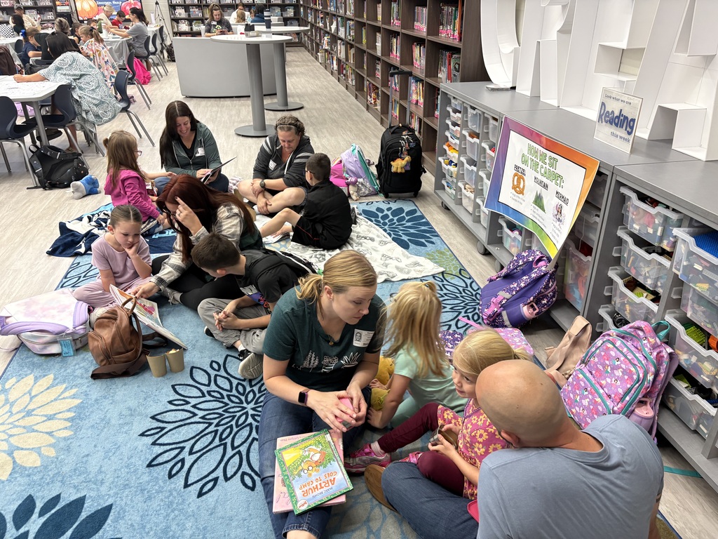 Parents and children reading in a library. 