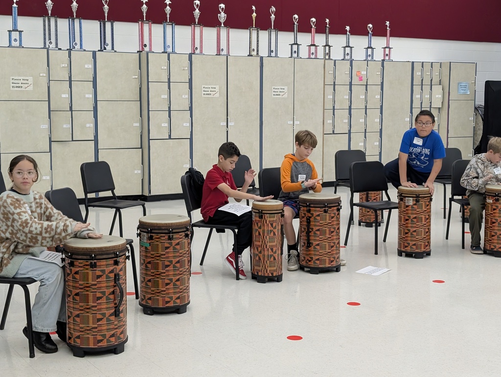Students are playing percussion in a gym.