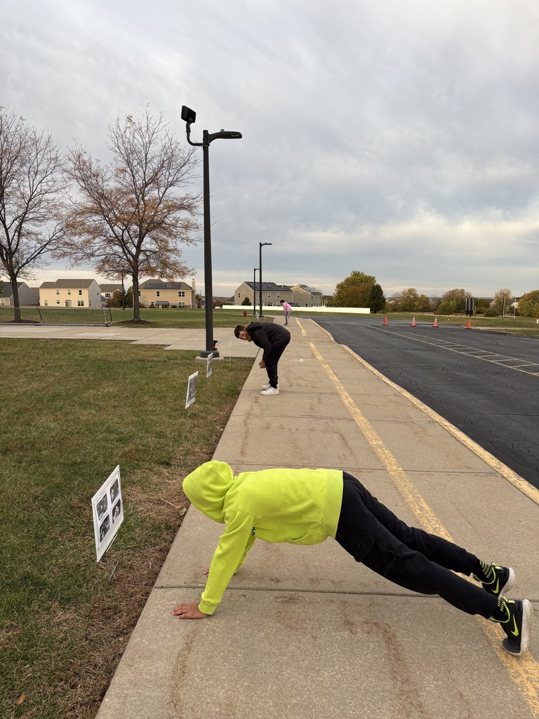 Students are reading signs in front of a school.