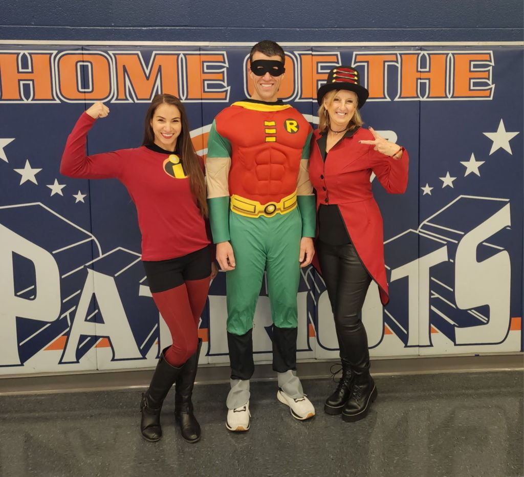 Three teachers dressed as superheroes.