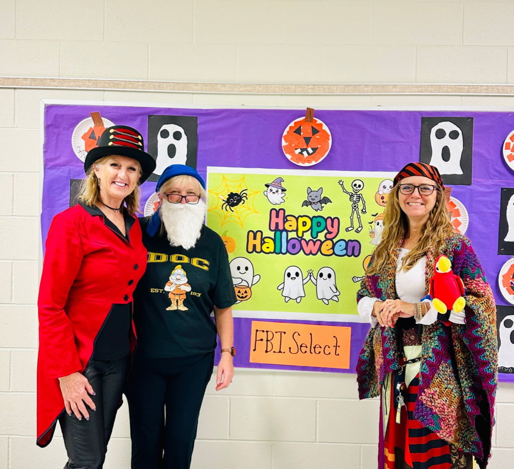 Three teachers in Halloween costumes.