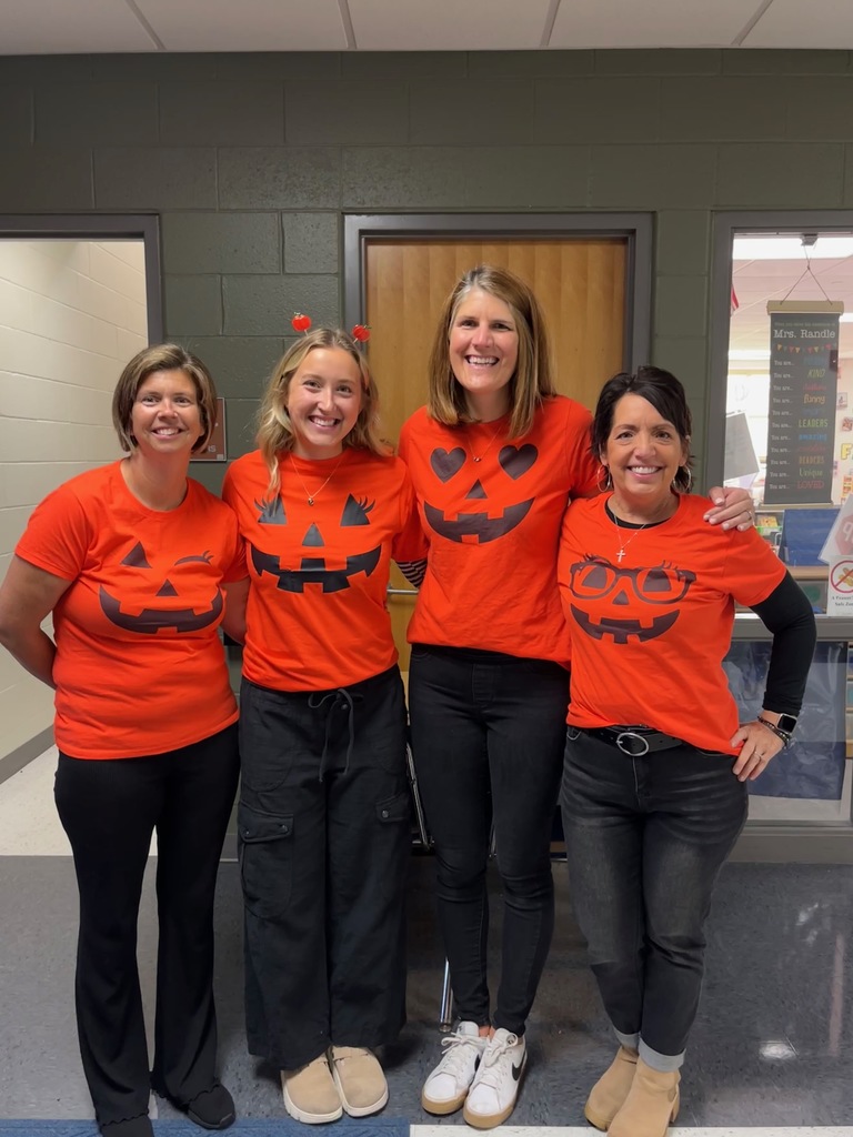 Four teachers with jack o lantern tshirts.