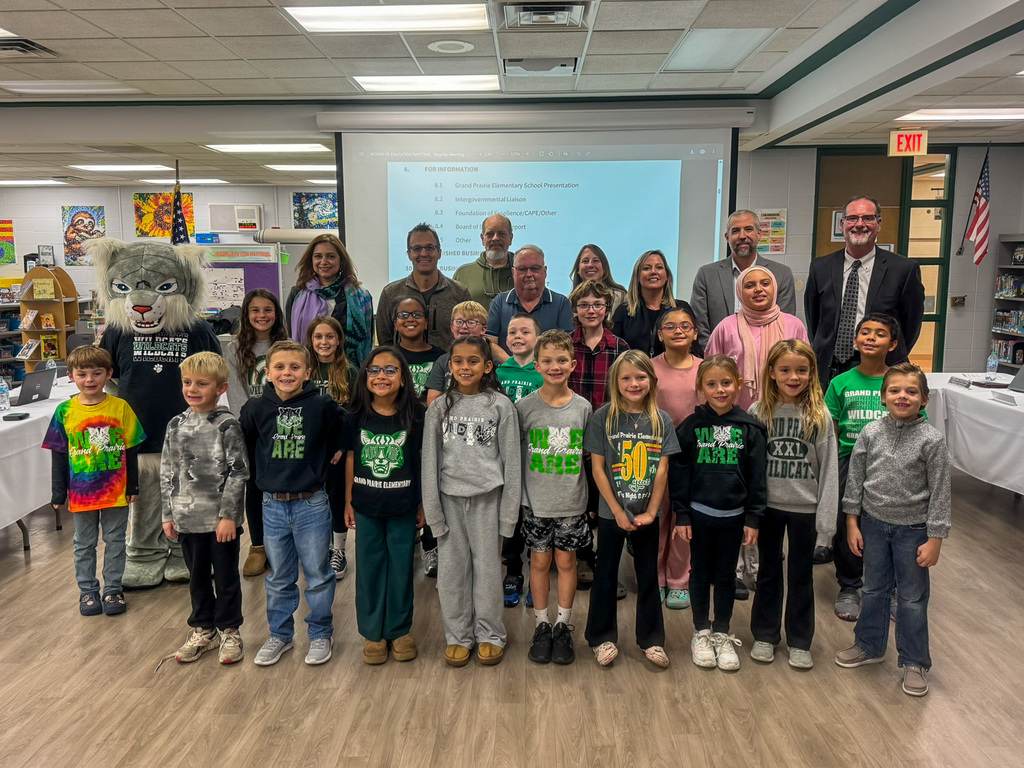 Group of students, board of education members and superintendent pose for photo