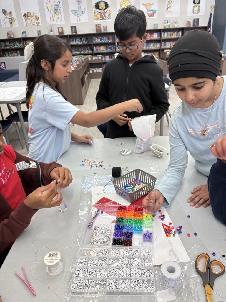 Students making, jewelry in a library.