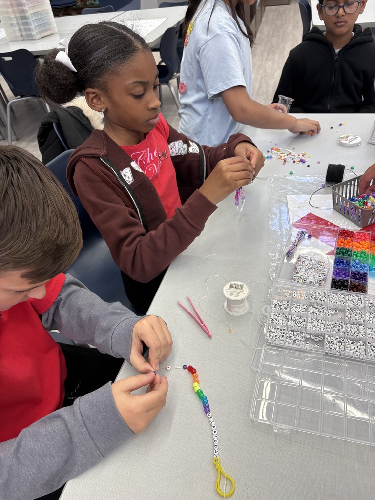 Students making, jewelry in a library.