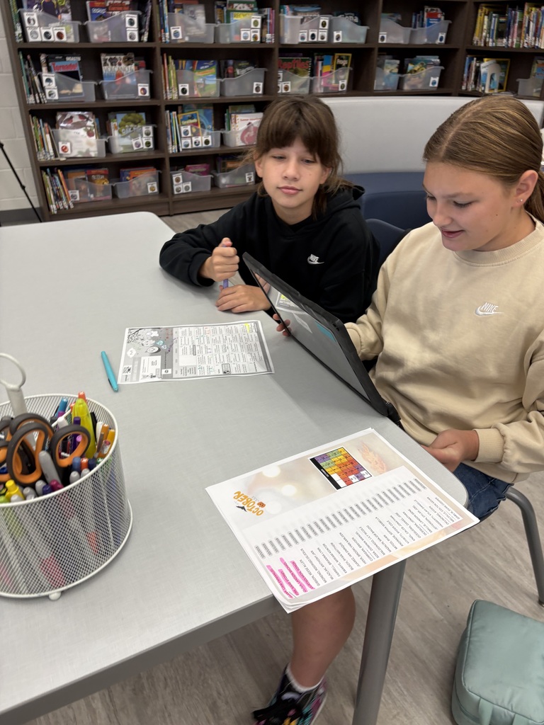 Two students writing a script on a computer