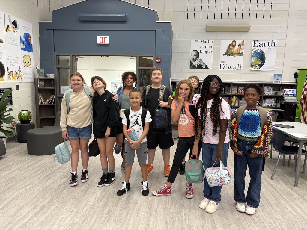 Nine students standing in a library