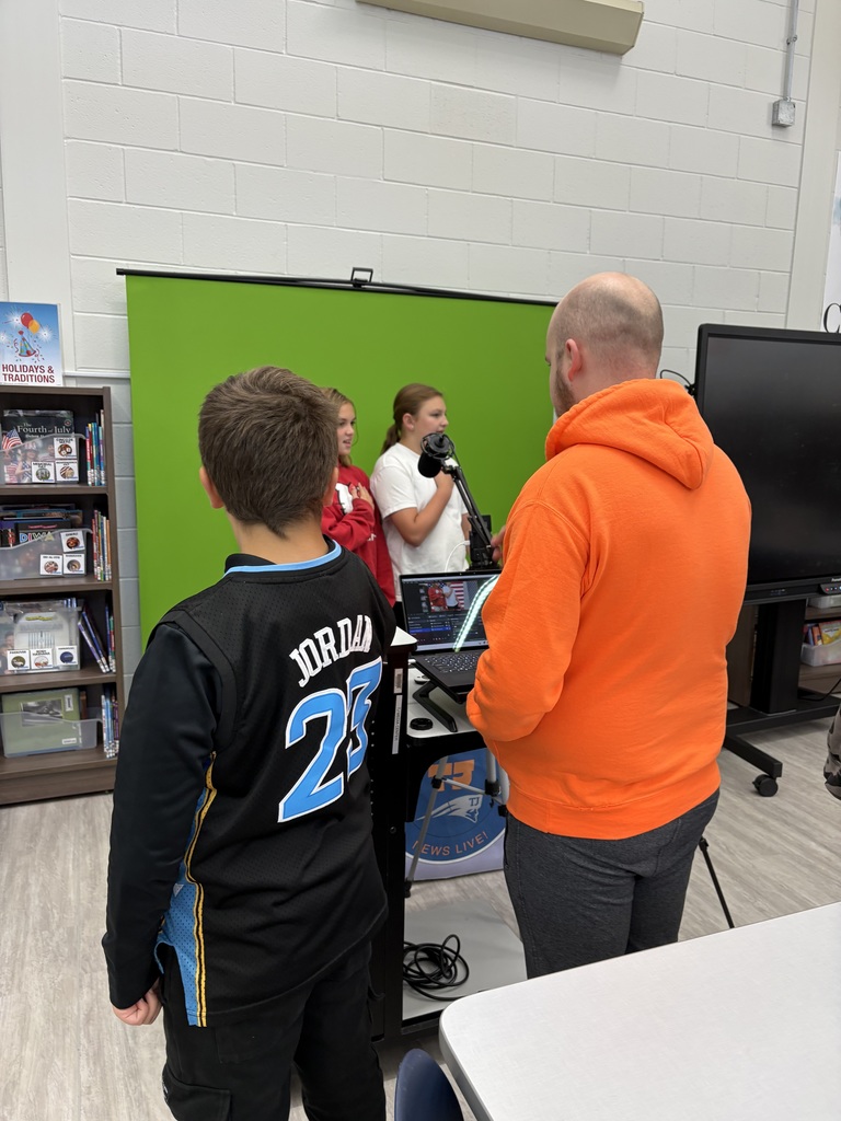 Three students and a teacher recording  morning announcements