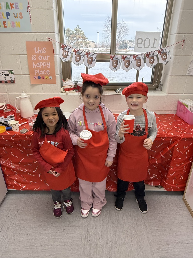 Three students wearing aprons and wearing chef's hats. 