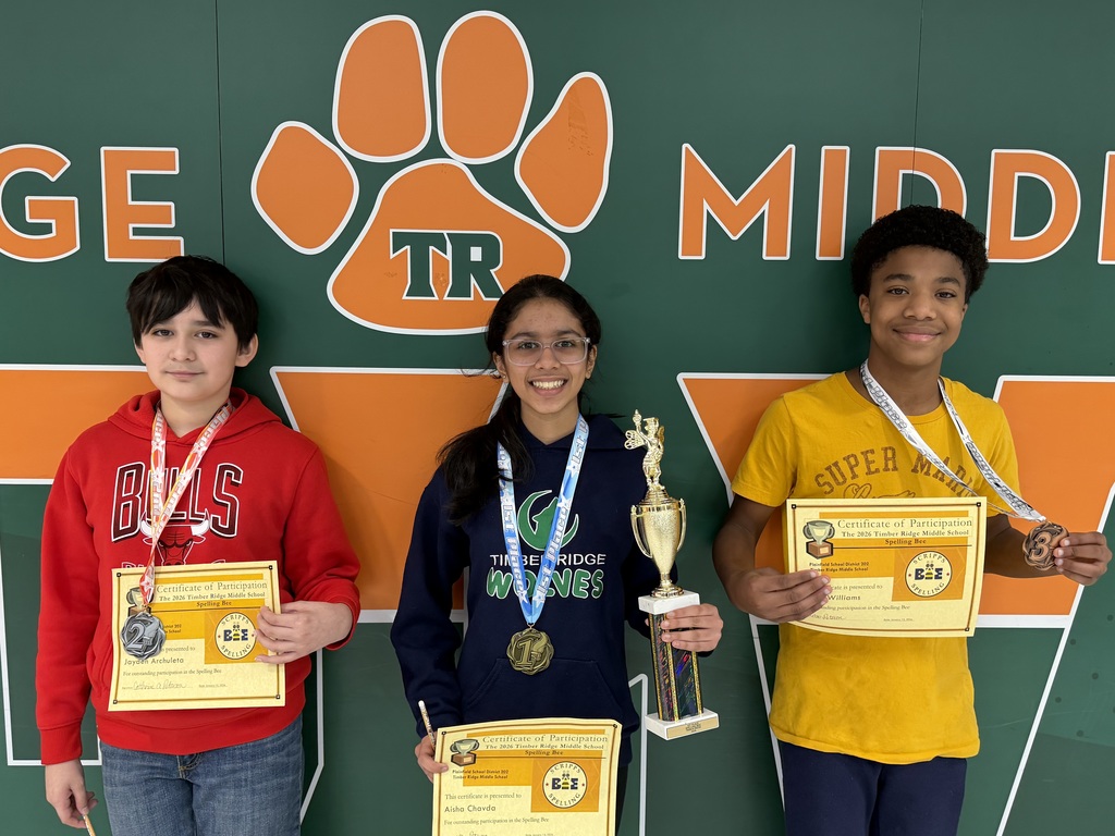 Three middle school students stand in line after winning spelling bee