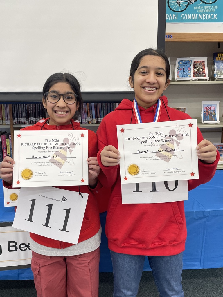 Umme-Haani Zaki (left) stands next to her sister Durrat-us-Sharaf Zaki (right) at the IJMS spelling bee.