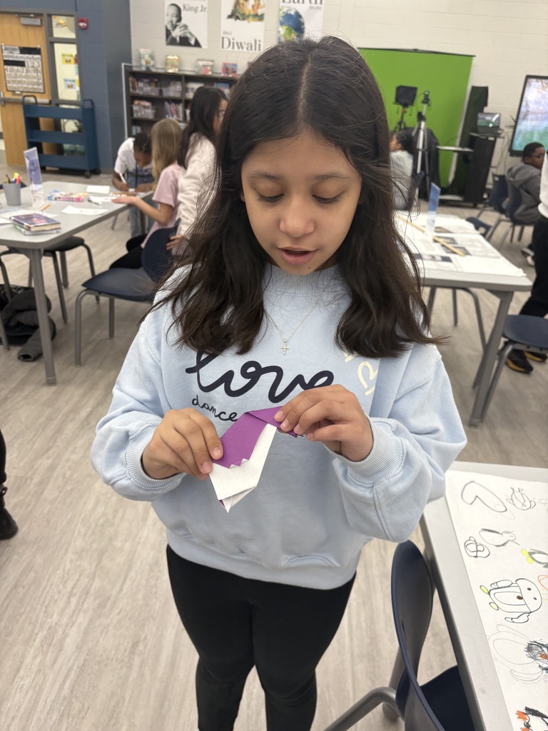 A student holding an origami penguin.  