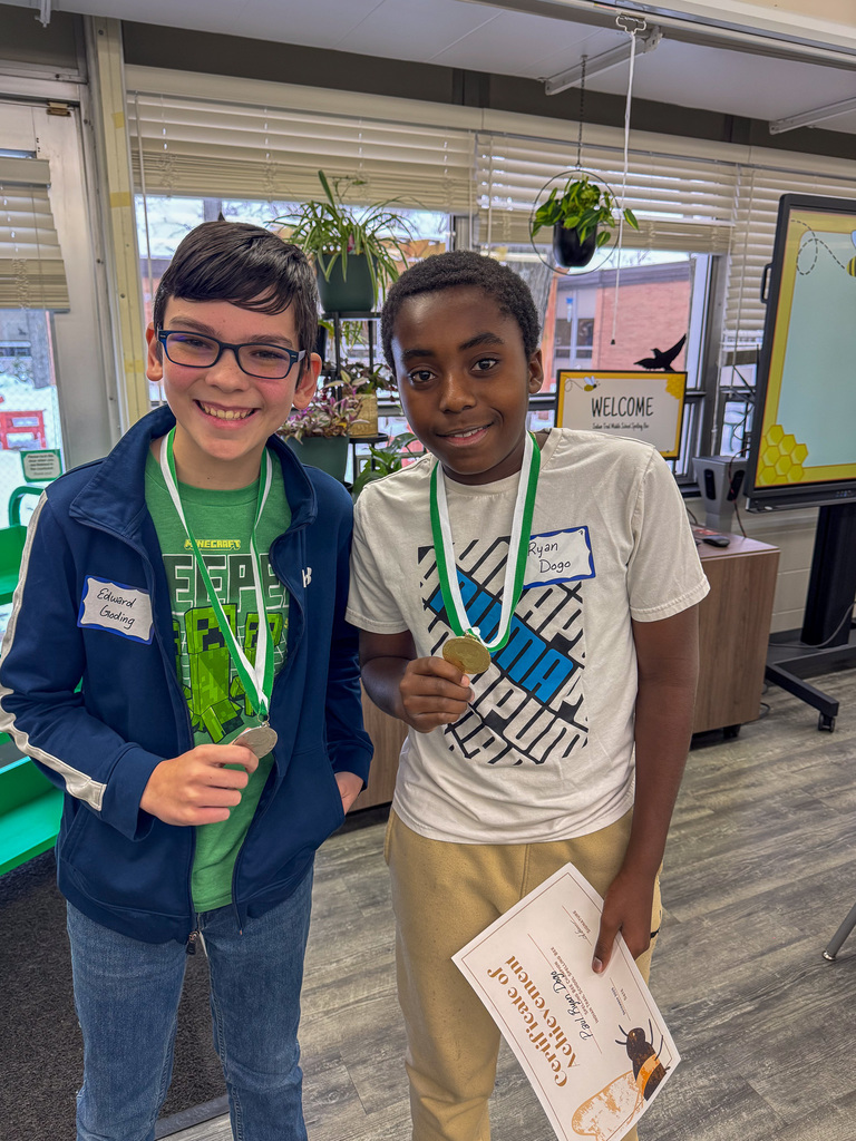 first and second place spelling bee winners hold up medals