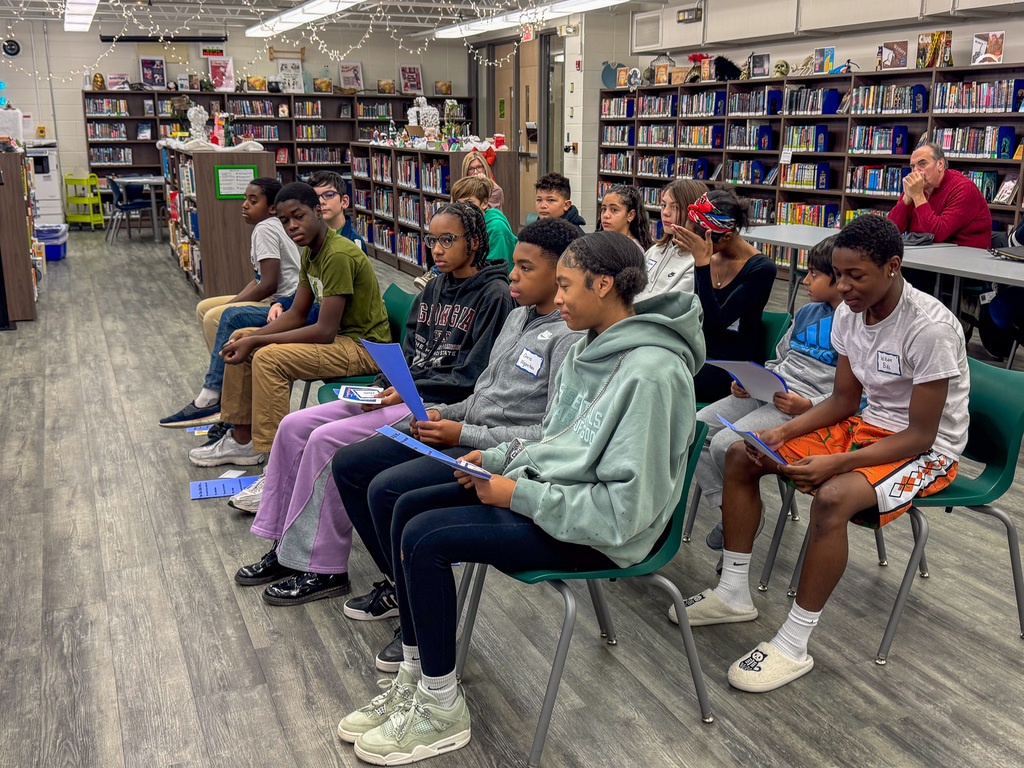 group of students sit in chairs during spelling bee