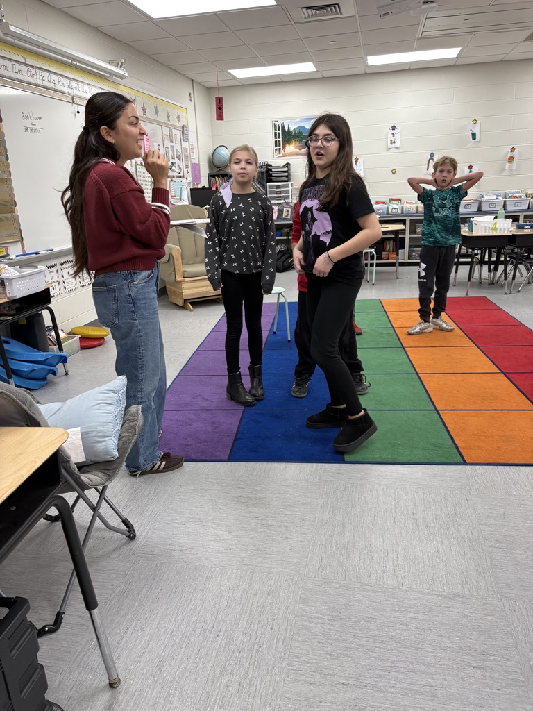 Students are standing in a classroom. 