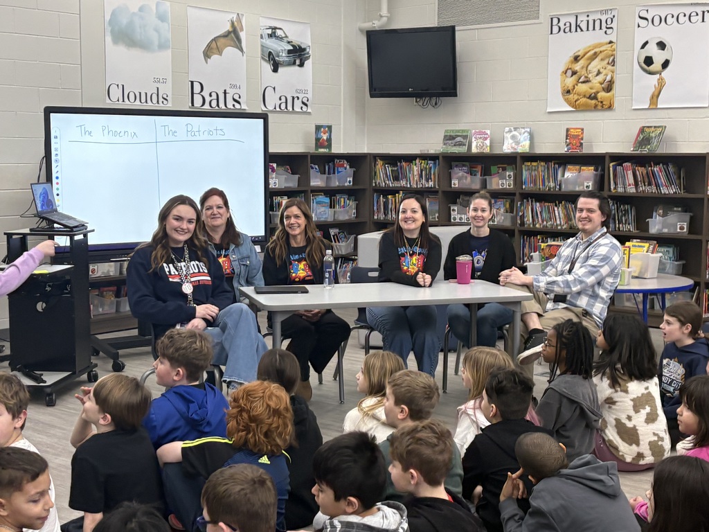 Students in a library watching a reading competition.