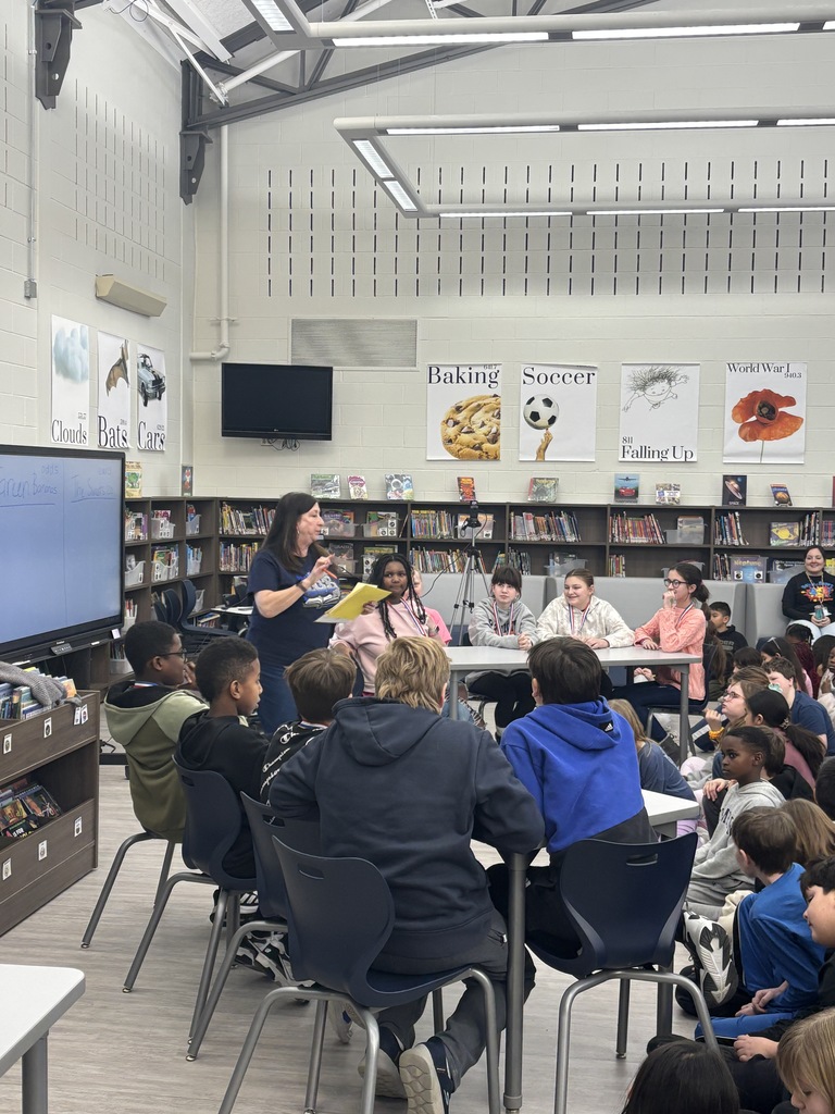 A teacher asking students a question in the library. 