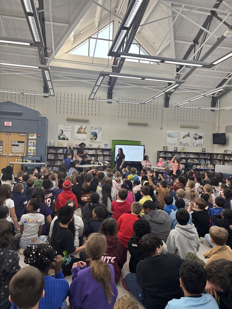 Students in a library watching a reading competition.