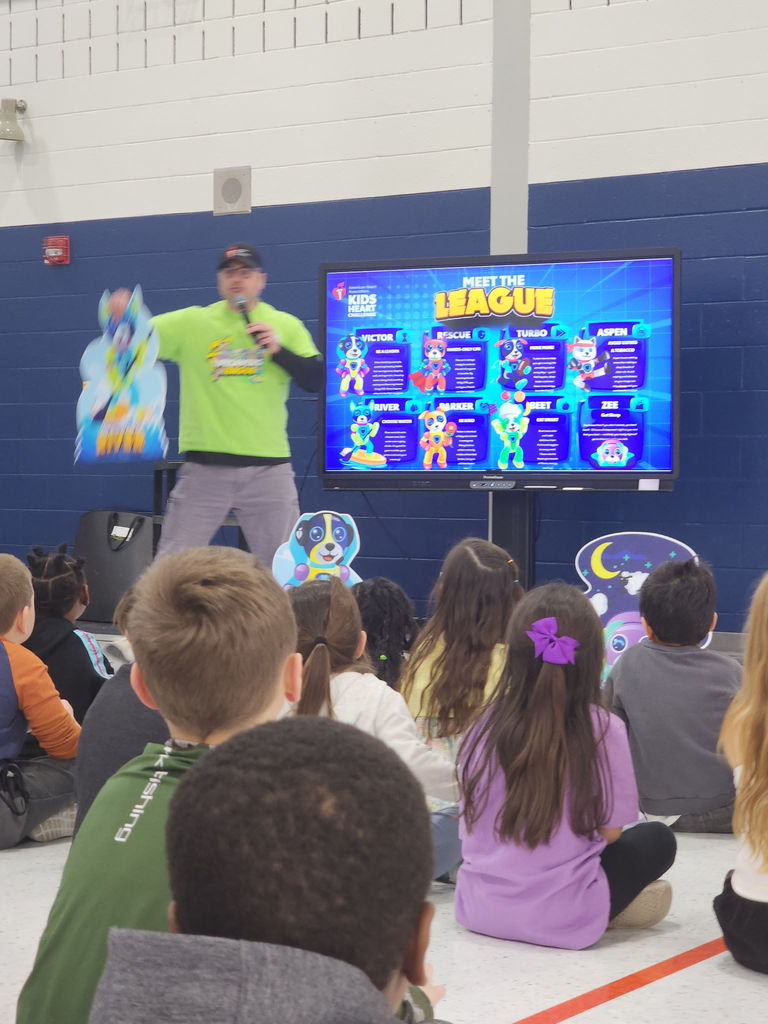 Students watching a presentation by the American Heart Association in a school gym.