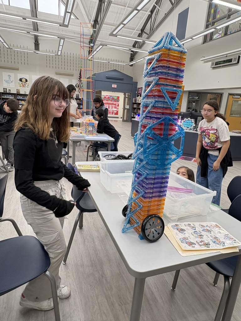Students building with magnetic shapes in a library