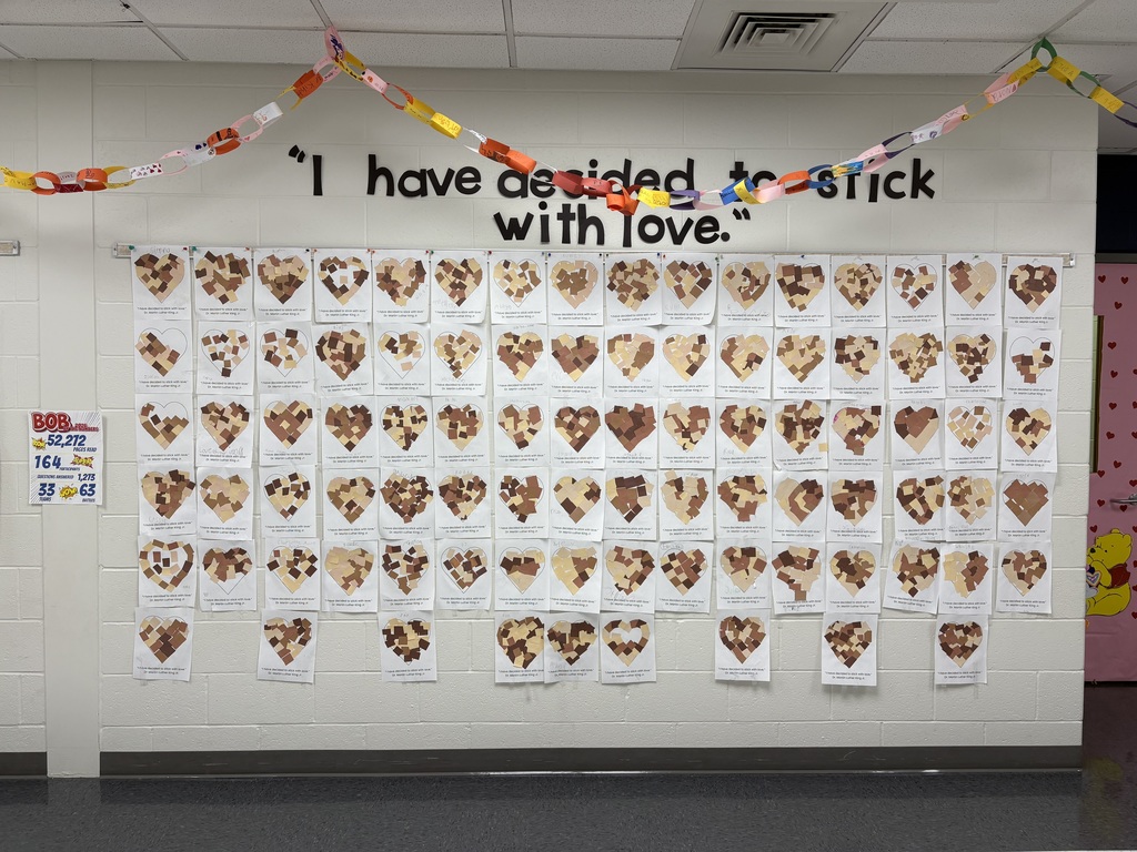A hallway display of hearts filled with small paper scraps.