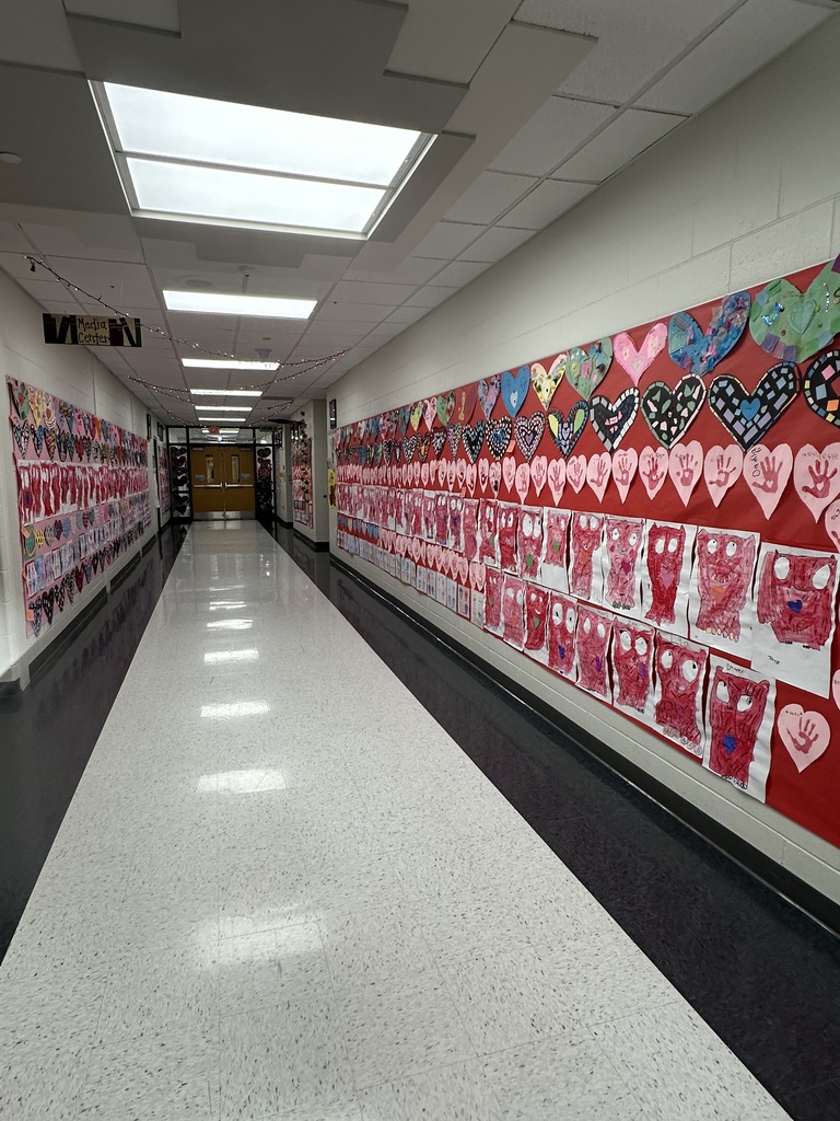Student's heart artwork displayed in a school hallway. 