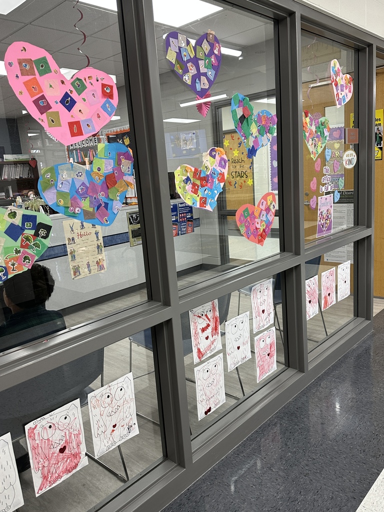 Student's heart artwork displayed in a school hallway. 