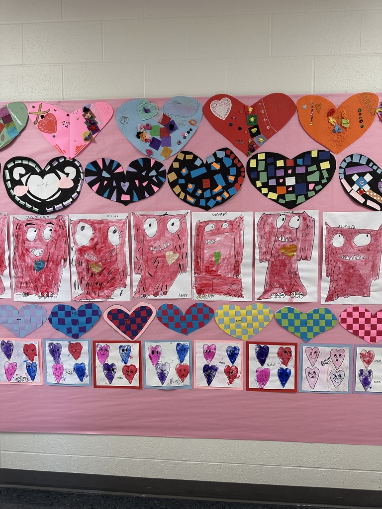 Student's heart artwork displayed in a school hallway. 