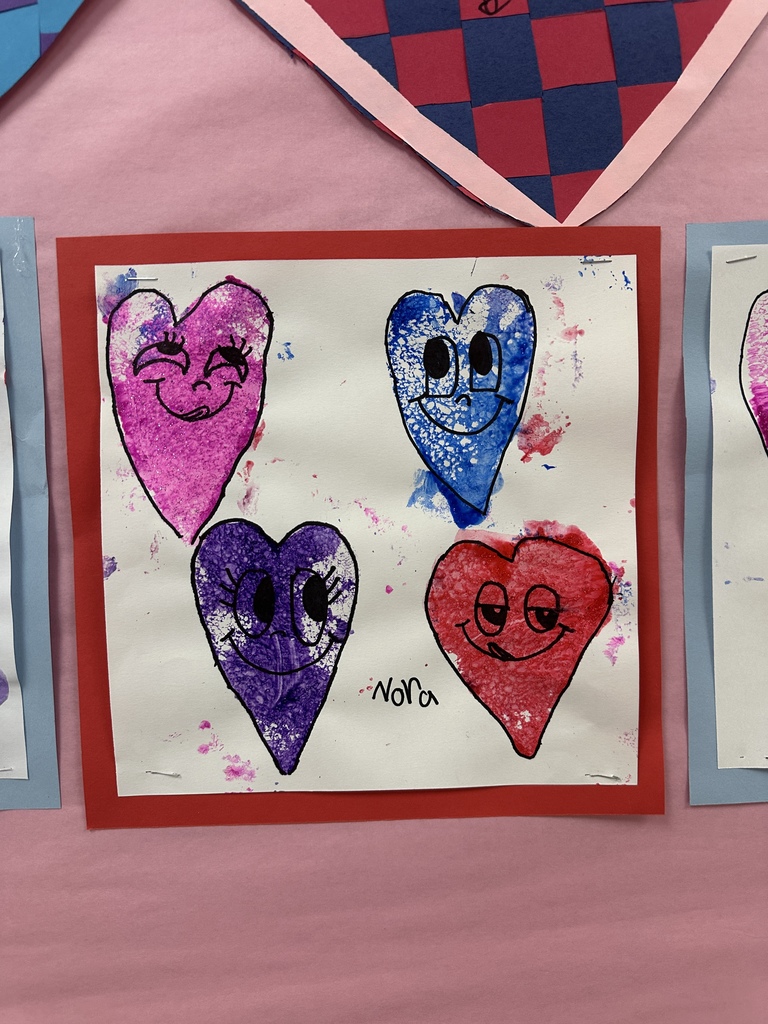 Student's heart artwork displayed in a school hallway. 