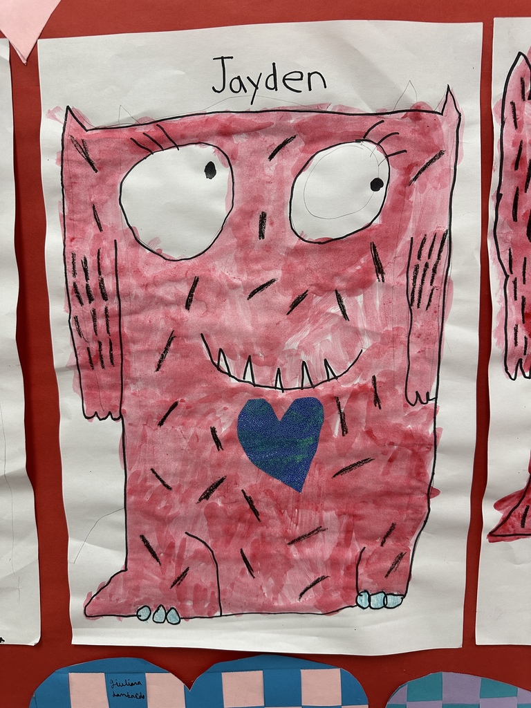 Student's heart artwork displayed in a school hallway. 