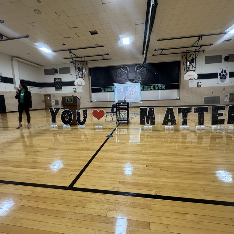 words You heart shape matter on gym floor woman standing to the far left speaking