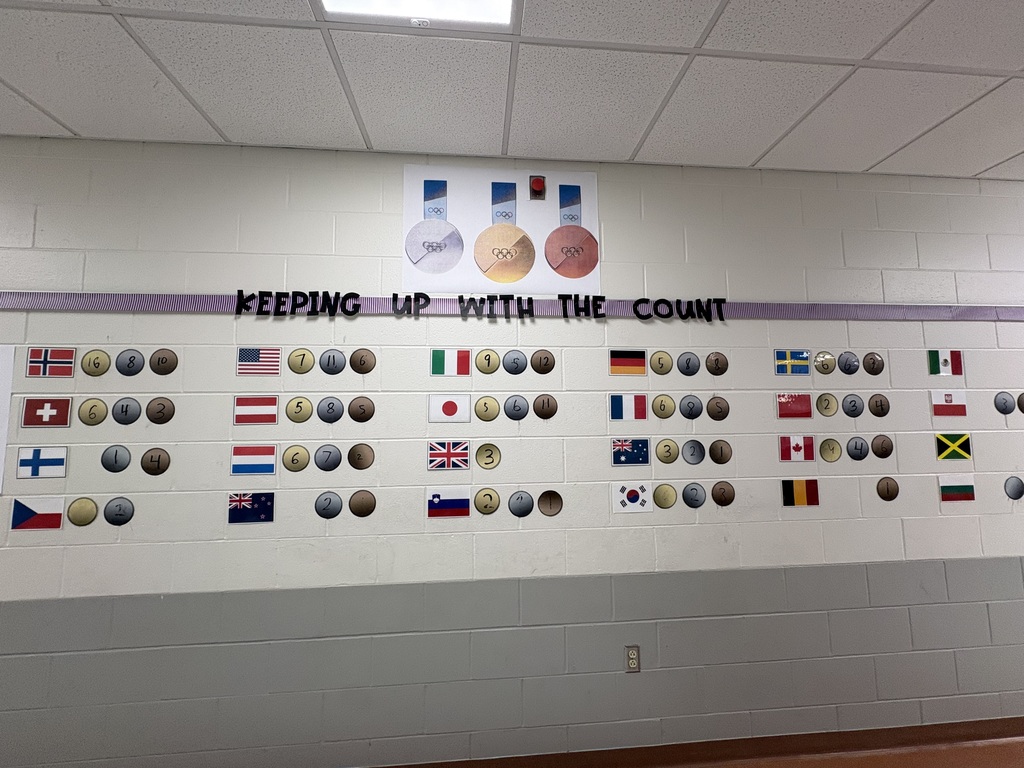 A wall in a school hallway, displaying Olympic medals