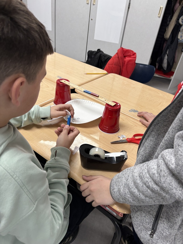 Two students working on a project with a magnet