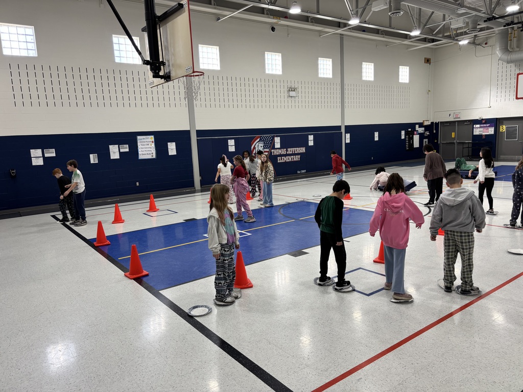 Students in a school gym playing an Olympic themed event.